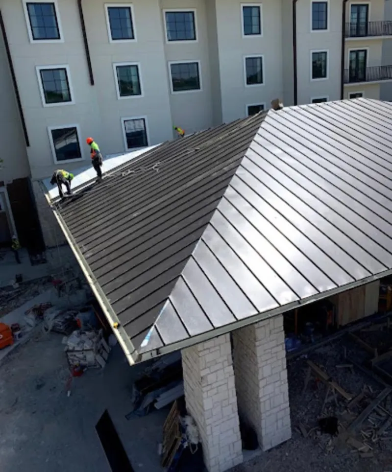 Crew installing standing seam metal roof panels on a commercial project in Yuba City